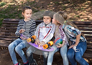 Happy girl and boy sitting in the park on a bench in spring