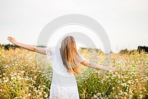 Happy girl on the camomile field, summer sunset. in a white dress. running and spinning, the wind in my hair, life style