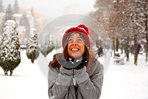 A happy girl catches snowflakes