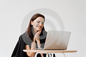 Happy girl chatting with family and friends via video call on white background. Successful business woman with laptop
