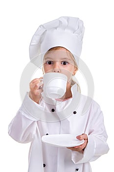 Happy girl chef white uniform isolated on white background. Drinking from the white cup holding a saucer. Portrait image