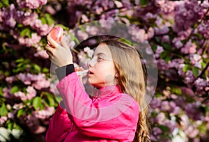 Happy girl in cherry flower. Sakura tree blooming. skincare spa. Natural cosmetics for skin. summer. Childhood. small