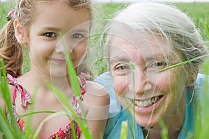 Happy girl child and grandmother in field