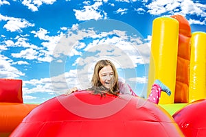Happy Girl Child on Inflate Castle Cloudscape photo