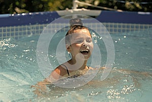 Happy girl child swim in swimming bath on sunny summer day, pool