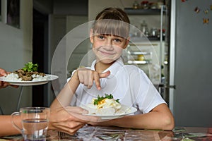 Happy girl chose one dish out of two offered by her mother for lunch