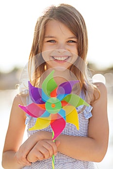 Happy girl with colorful pinwheel toy