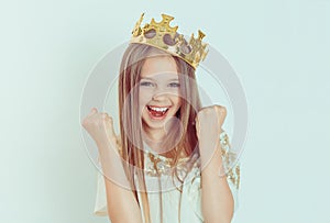 Happy girl with crown pumping fists celebrates success victory