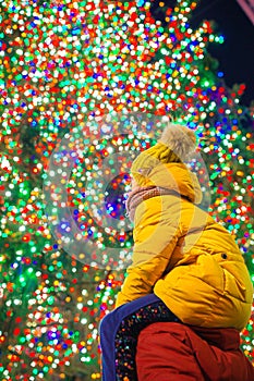 Happy girl with dad on the background of the Rockefeller Christmas tree in New York