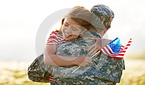 Happy girl daughter with american flag hugging father came back from US army