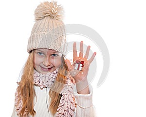 Happy girl demonstrating Christmas symbols painted on hands. Christmas present