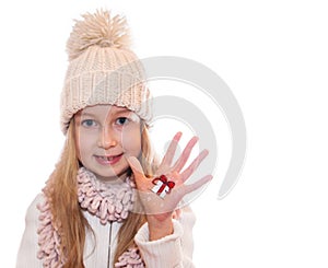 Happy girl demonstrating Christmas symbols painted on hands. Christmas present