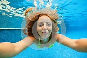 Happy girl dive underwater with fun in swimming pool