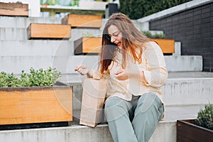 Happy Girl doing ecological shopping with paper bags in hand. Elegant young 30s woman formally dressed, opens brown