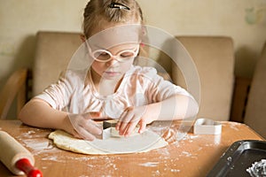 Happy girl with Down syndrome bakes cookies