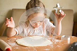 Happy girl with Down syndrome bakes cookies