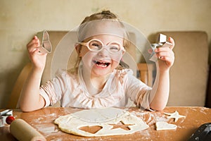 Happy girl with Down syndrome bakes cookies