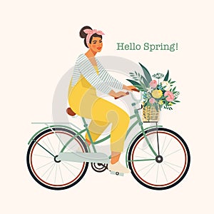 Happy girl dressed in trendy clothes riding city bicycle with flower bouquet in front basket. Adorable young hipster