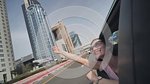 Happy girl driving a car in Dubai.