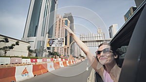 Happy girl driving a car in Dubai.
