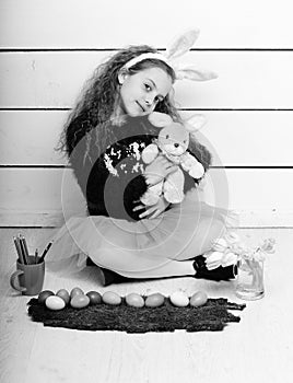 Happy girl with easter rabbit toy, pencil, tulip flowers, eggs