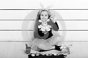 Happy girl with easter rabbit toy, pencil, tulip flowers, eggs