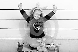 Happy girl with easter rabbit toy, pencil, tulip flowers, eggs