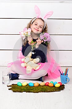 Happy girl with easter rabbit toy, pencil, tulip flowers, eggs