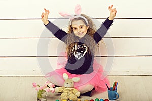 Happy girl with easter rabbit toy, pencil, tulip flowers, eggs