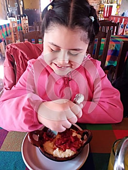 Happy girl eating chorizo â€‹â€‹con queso in a country Mexican style restaurant