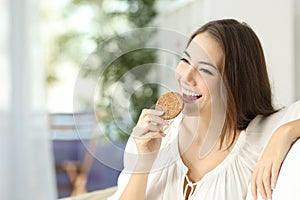 Happy girl eating a dietetic cookie photo