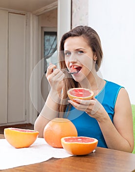 Happy girl eating grapefruit