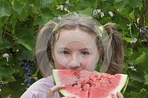 Happy girl eats watermelon in summer. Concept of happy childhood, vacation, vitamins. Selective focus, blur