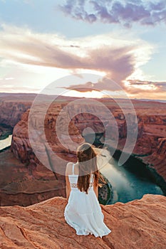 Happy girl on the edge of the cliff at Horseshoe Band Canyon in Page, Arizona. Adventure and tourism concept. Beautiful