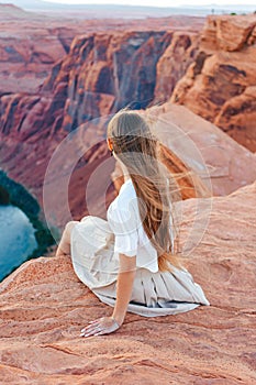 Happy girl on the edge of the cliff at Horseshoe Band Canyon in Page, Arizona. Adventure and tourism concept. Beautiful