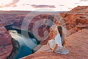 Happy girl on the edge of the cliff at Horseshoe Band Canyon in Page, Arizona. Adventure and tourism concept. Beautiful