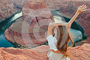 Happy girl on the edge of the cliff at Horseshoe Band Canyon in Page, Arizona. Adventure and tourism concept. Beautiful
