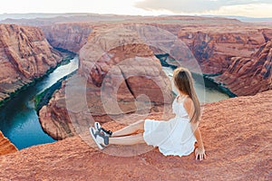 Happy girl on the edge of the cliff at Horseshoe Band Canyon in Page, Arizona. Adventure and tourism concept. Beautiful