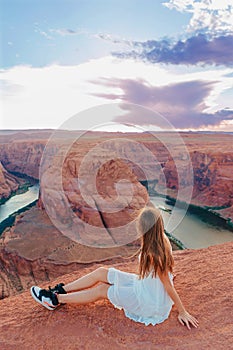 Happy girl on the edge of the cliff at Horseshoe Band Canyon in Page, Arizona. Adventure and tourism concept. Beautiful