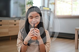 Happy girl enjoy drinking pearl pearl bubble milk tea through a straws.