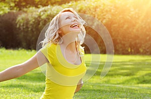 Happy girl enjoying the Nature on green grass.