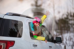 Happy girl enjoying winter sports  cheerful portrait of a girl in the car and in a ski mask  arrived at the ski resort  tourist photo