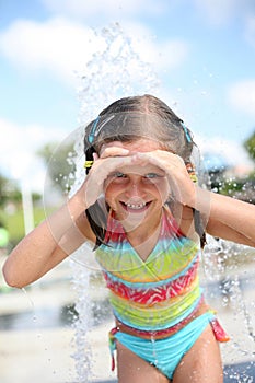 Happy girl enjoys summer day at swimming pool.