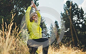 Happy girl exercising outdoors in sun summer day, activity with stretcharms and  legs in park. Smile woman stretching exercises