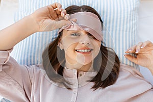 happy girl in eye sleeping mask lying in bed