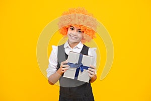 Happy girl face, positive and smiling emotions. Child with gift present box on isolated studio background. Gifting for