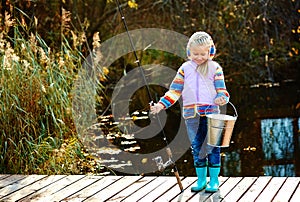 Happy girl, fishing with a fishing rod and a bucket of catch, sm