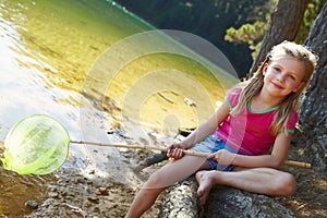 Happy girl fishing at lake