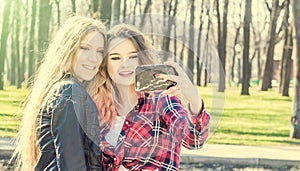 Happy girl friends taking a selfie on a summer day