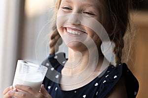 Happy girl with funny moustache drinking milk